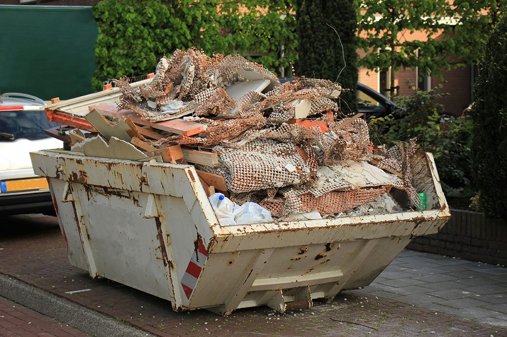 Containerdienst – gefüllter Absetzcontainer mit Bauabfällen
